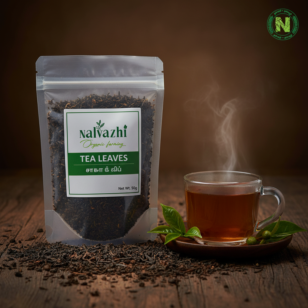 Nalvazhi Tea Leaves 50g packet on rustic dark wooden surface with broken tea leaves and steaming glass cup of amber tea