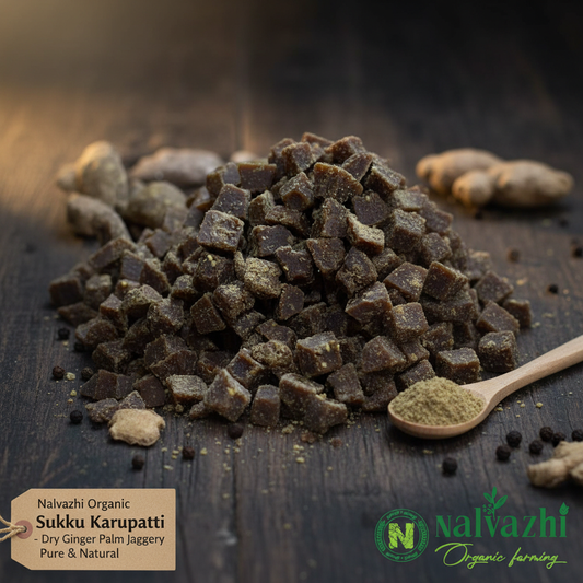 Nalvazhi Organic Sukku Karupatti small dark brown black cube pieces with speckled ginger pepper coating on dark wooden surface