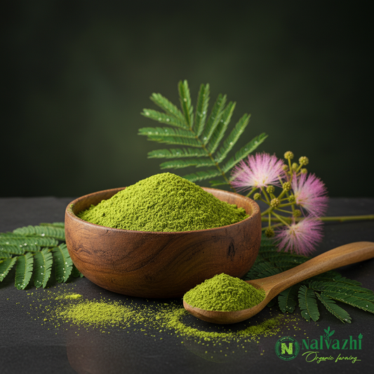 Nalvazhi Organic Arappu Thool shikakai powder in wooden bowl with fresh arappu plant leaves and pink flowers