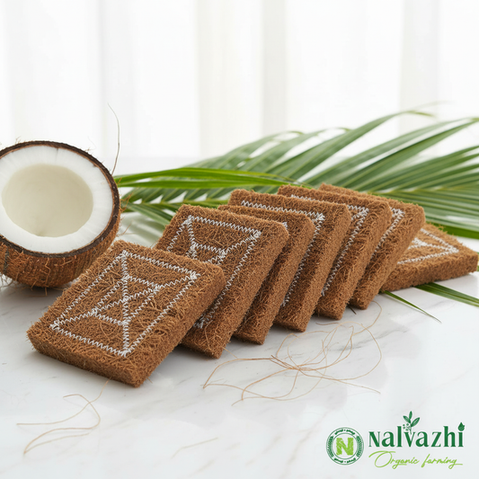 Nalvazhi Coconut Coir Scrub multiple scrubbers arranged in a row showing brown coir fibre texture with white zigzag grid stitching pattern on white marble with halved coconut and green coconut leaves