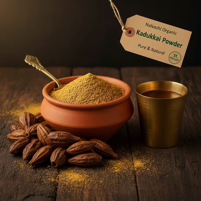 Kadukkai golden-brown powder in terracotta bowl with whole dried Terminalia chebula fruits and brass tumbler of herbal decoction