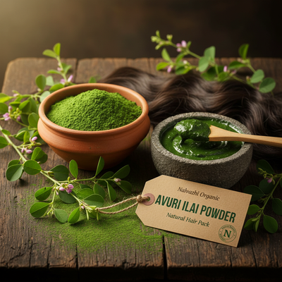 Avuri Ilai herbal powder in terracotta bowl with freshly mixed green hair pack paste, Avuri plant leaves and flowers