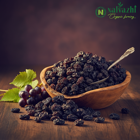 Plump black dry grapes in a rustic wooden bowl with Nalvazhi logo